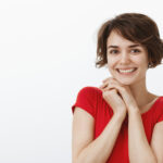 Pleased Cute Silly Happy Woman Short Haircut Red T Shirt Clench Hands Shoulder Smiling Admiration Joy Look Fascinated Camera Impressed Grateful Awesome Wonderful Gift Thanking Friend Dearly