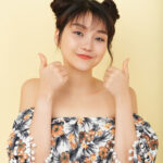 Smiling Asian Girl Bare Shoulder Top Posing Studio With Thumbs Up